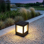 Square Black Solar Fence Post Light – lit on a gravel path at dusk