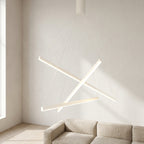 White Linear LED Chandelier – lit crossed light bars above a beige sofa