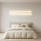 Wooden Up & Down LED Wall Light – lit above a bed in a bright bedroom