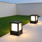 Square Black Solar Fence Post Light – two lanterns lit on a patio at dusk