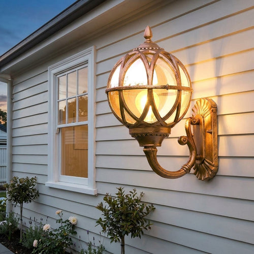 Bird's Nest Outdoor Wall Lantern – antique brass finish on a weatherboard house