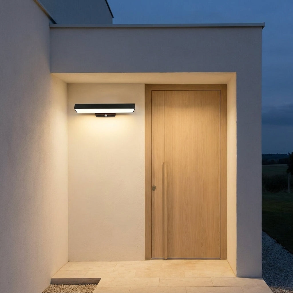 Rectangular Motion Sensor Outdoor Wall Light – mounted beside a front door, lit at night