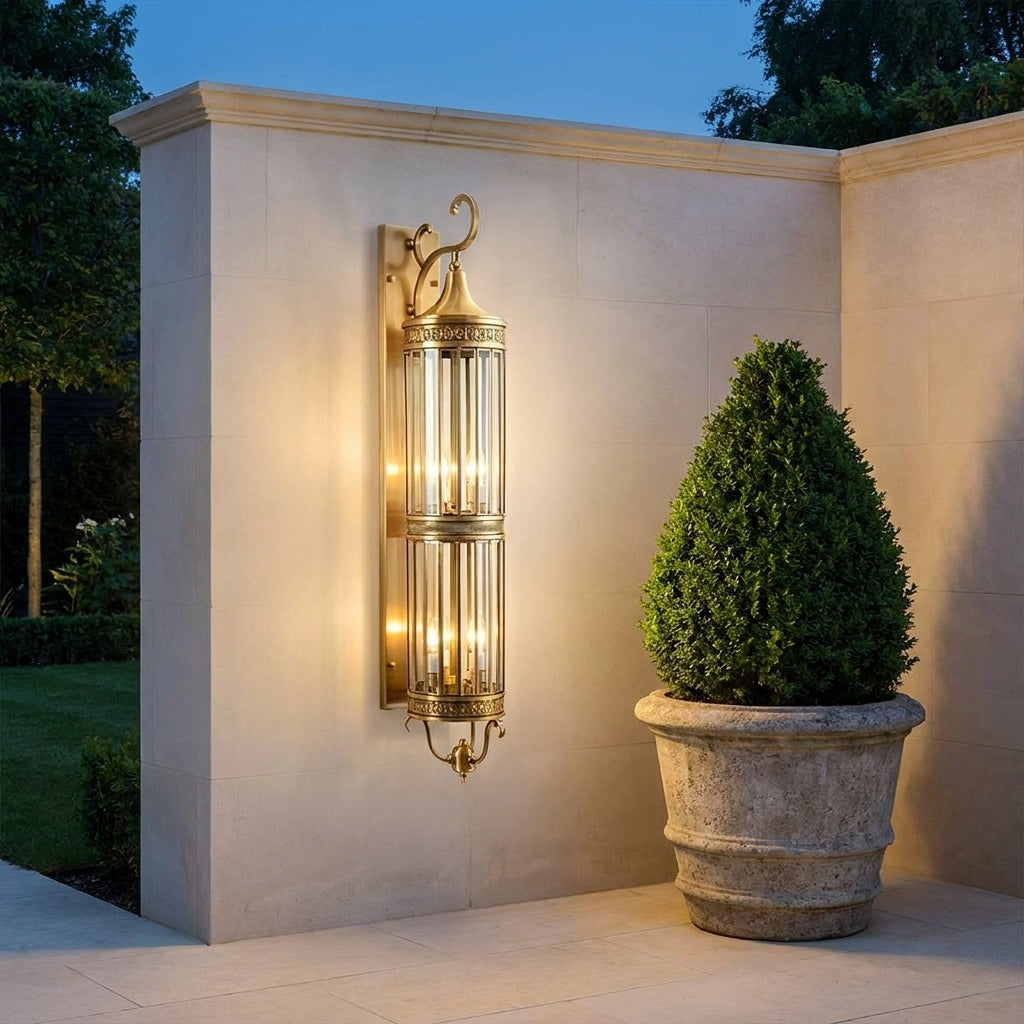 Mid Century Copper Outdoor Wall Lantern – mounted on an exterior corner wall at dusk with a potted plant