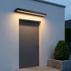 Rectangular Motion Sensor Outdoor Wall Light – mounted above a door, lit at dusk