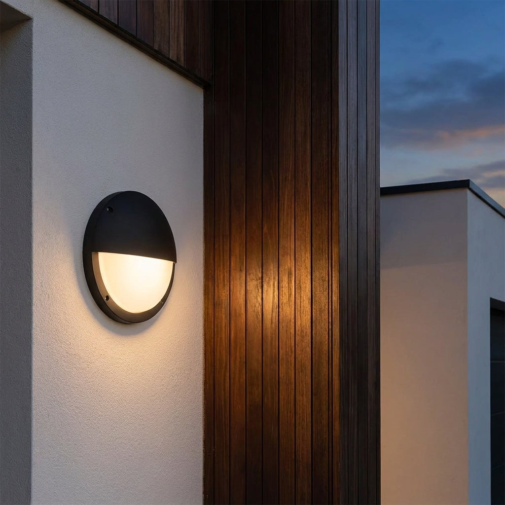 Round Outdoor LED Porch Wall Light – mounted against timber cladding at dusk