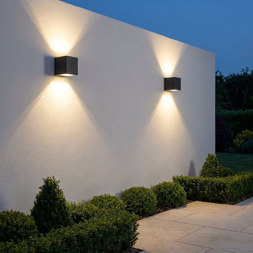 Square Outdoor Up & Down Wall Light – two lights mounted on a wall above hedging