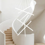 White Linear LED Chandelier – lit fixture hanging above a curved staircase