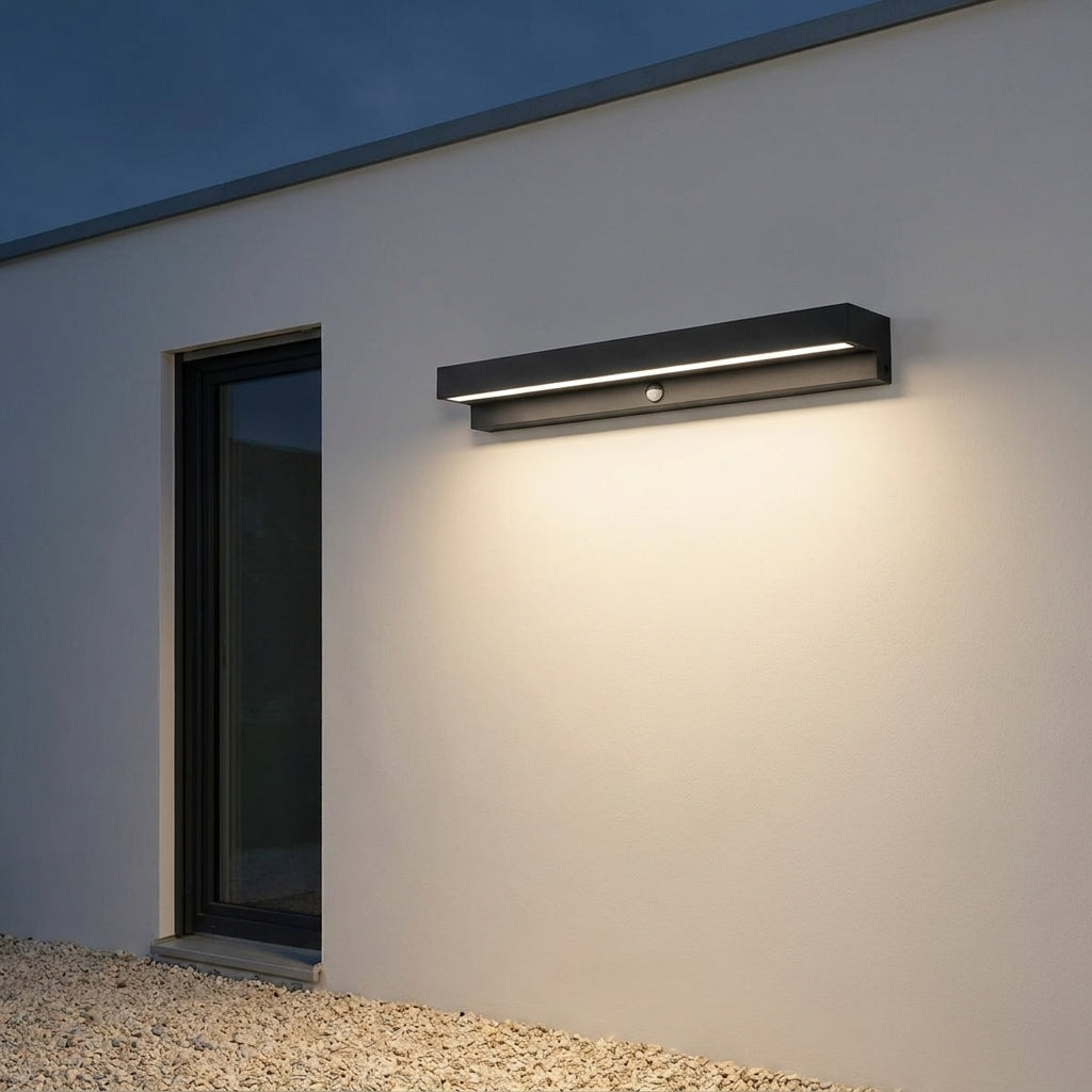 Rectangular Motion Sensor Outdoor Wall Light – mounted on a wall beside a window, lit