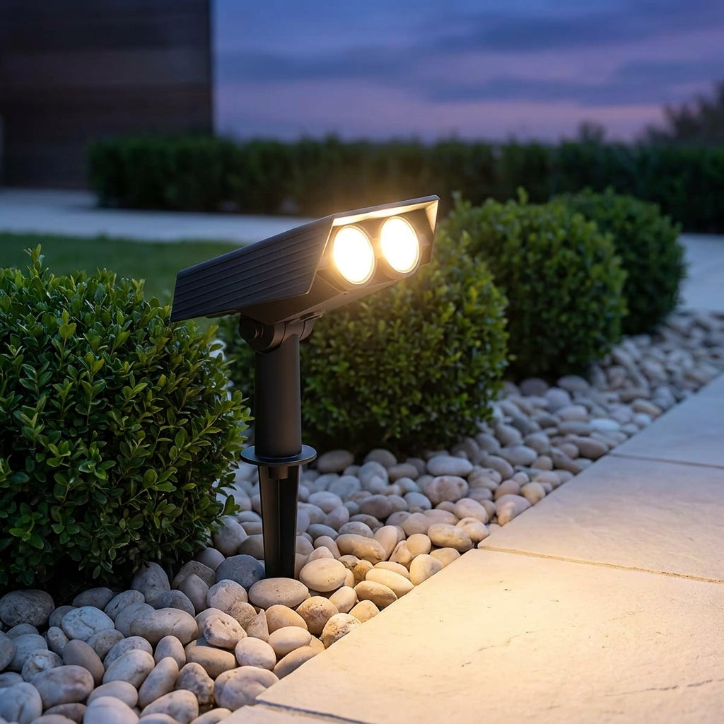 Solar Zoom Garden Spotlight – close-up beside pebbles and box hedging at dusk