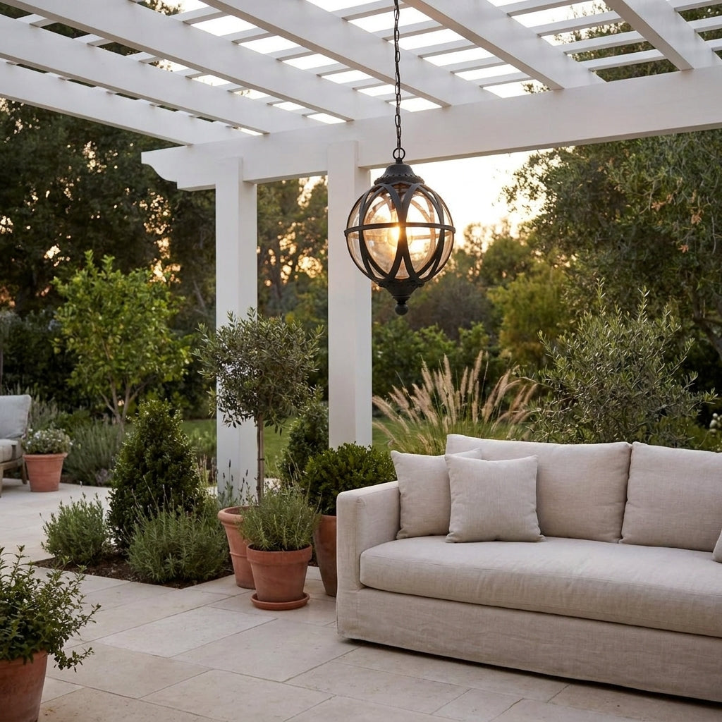 Outdoor Glass Ball Chandelier – hanging over an outdoor sofa under a pergola at dusk