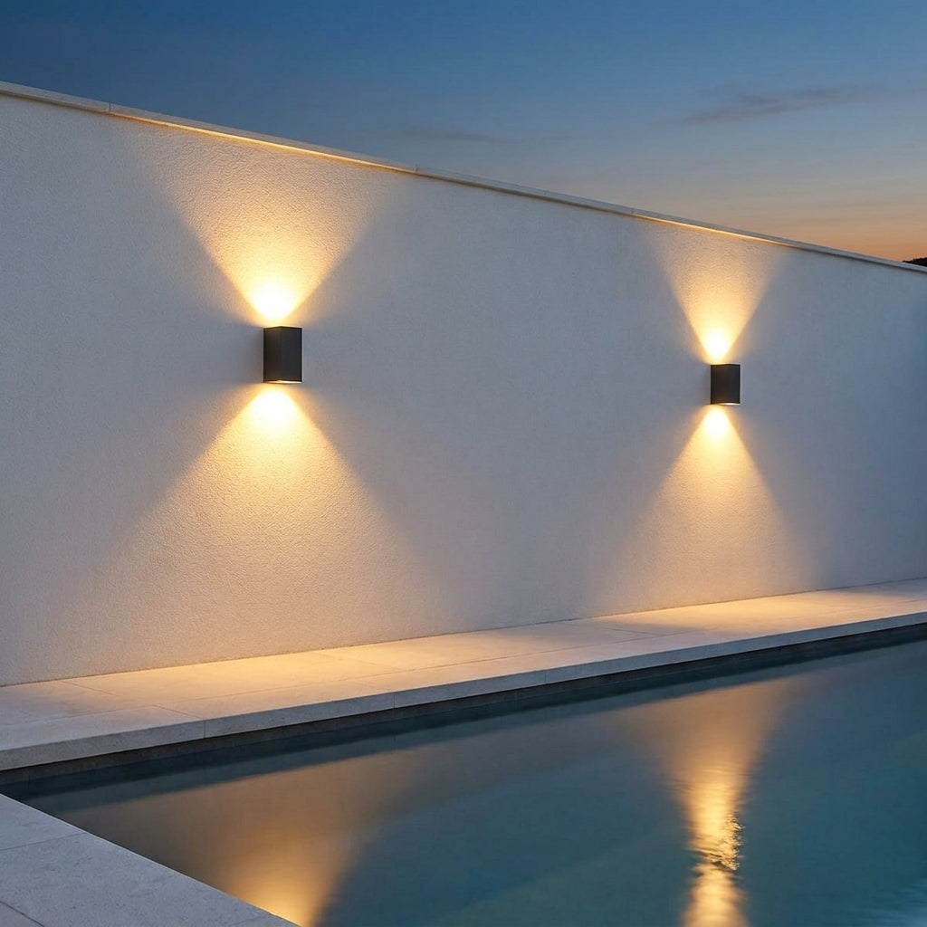 Square Outdoor Up & Down Wall Light – two lights mounted on a wall beside a pool