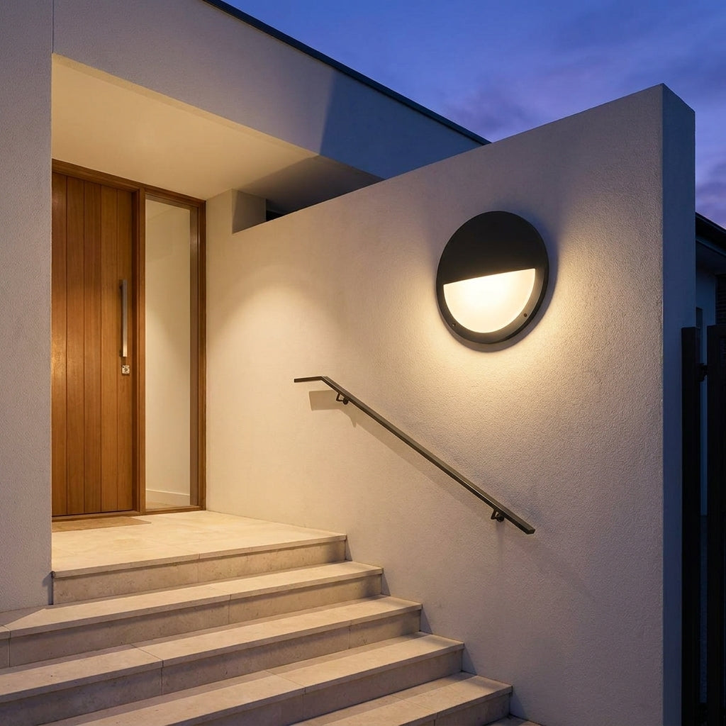 Round Outdoor LED Porch Wall Light – mounted above a staircase handrail at dusk