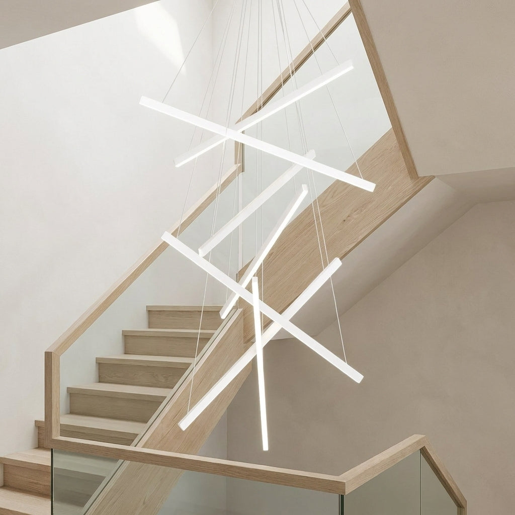 White Linear LED Chandelier – lit fixture above a light wood staircase