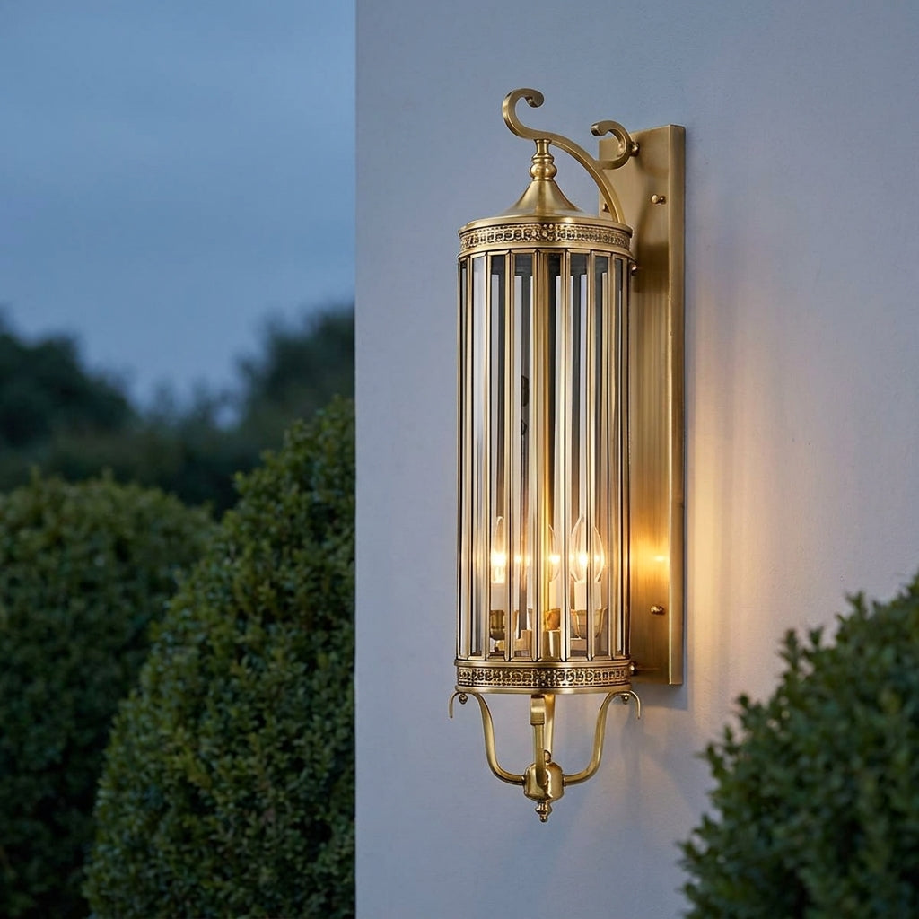 Mid Century Copper Outdoor Wall Lantern – close-up mounted on a wall lit at dusk among hedges
