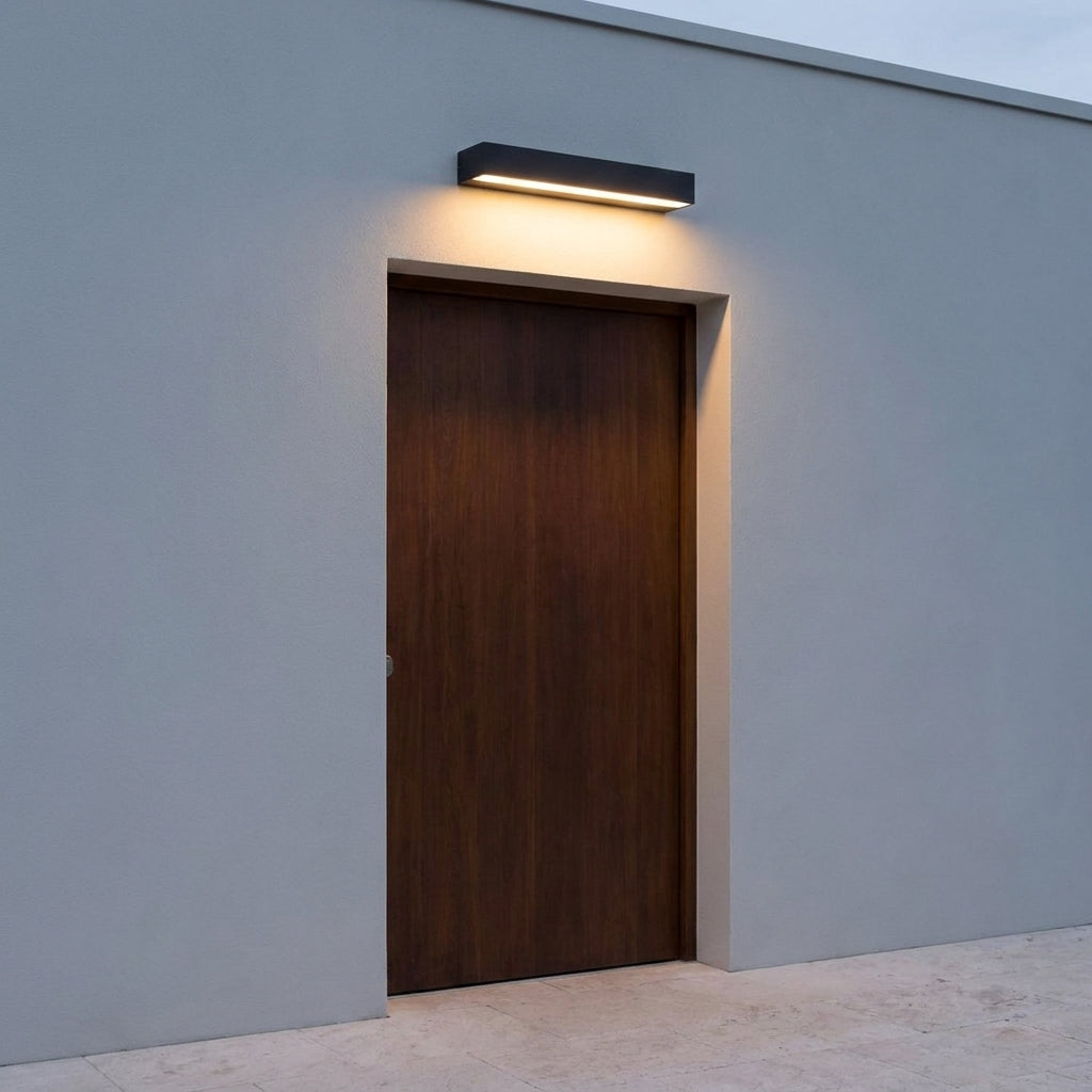 Slim Outdoor LED Wall Washer Light – mounted above a wooden door, grey wall