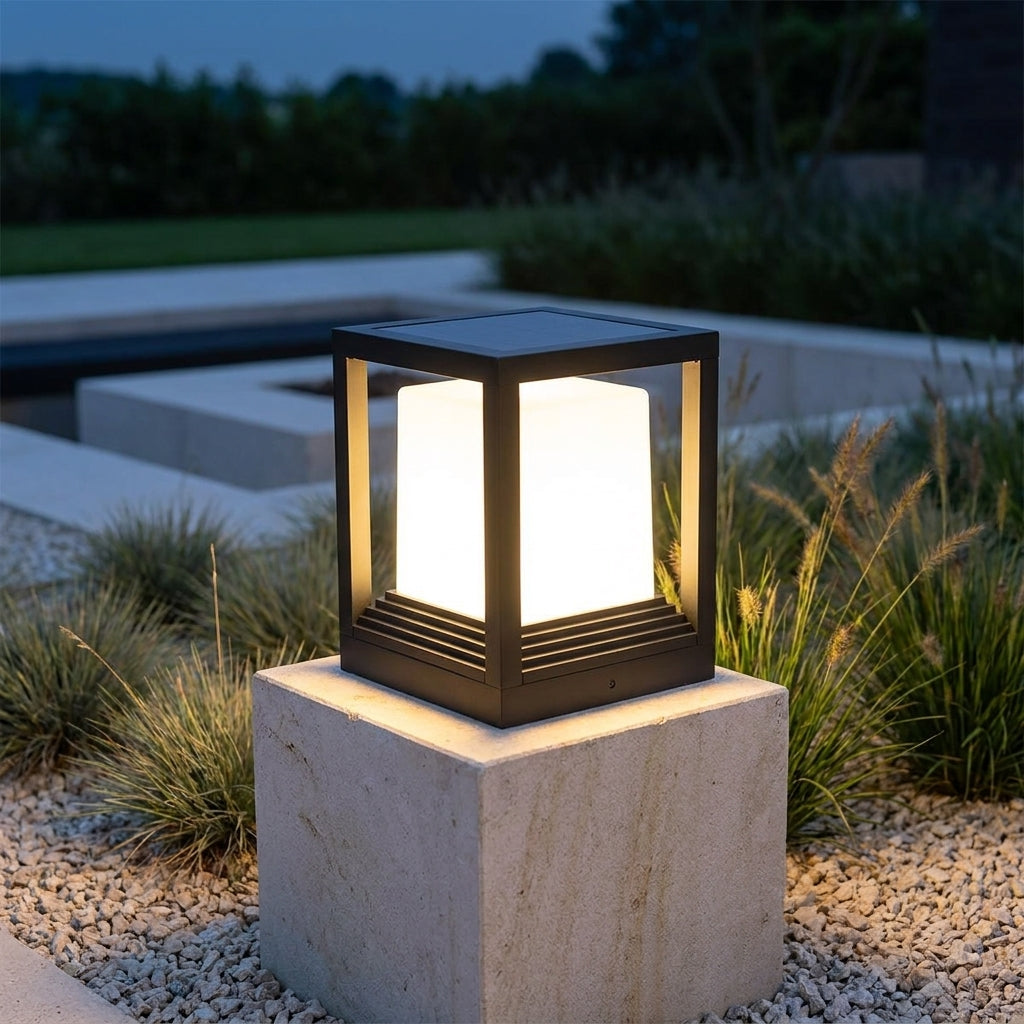 Square Black Solar Fence Post Light – lit on a stone plinth beside a pool