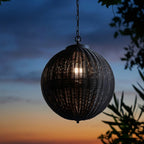 Black Rattan Outdoor Pendant Lantern – single lantern hanging against a sunset sky