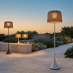 Woven Solar Outdoor Floor Lamp – lit on a terrace with lamps at dusk