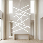 White Linear LED Chandelier – lit fixture between tall curtained windows