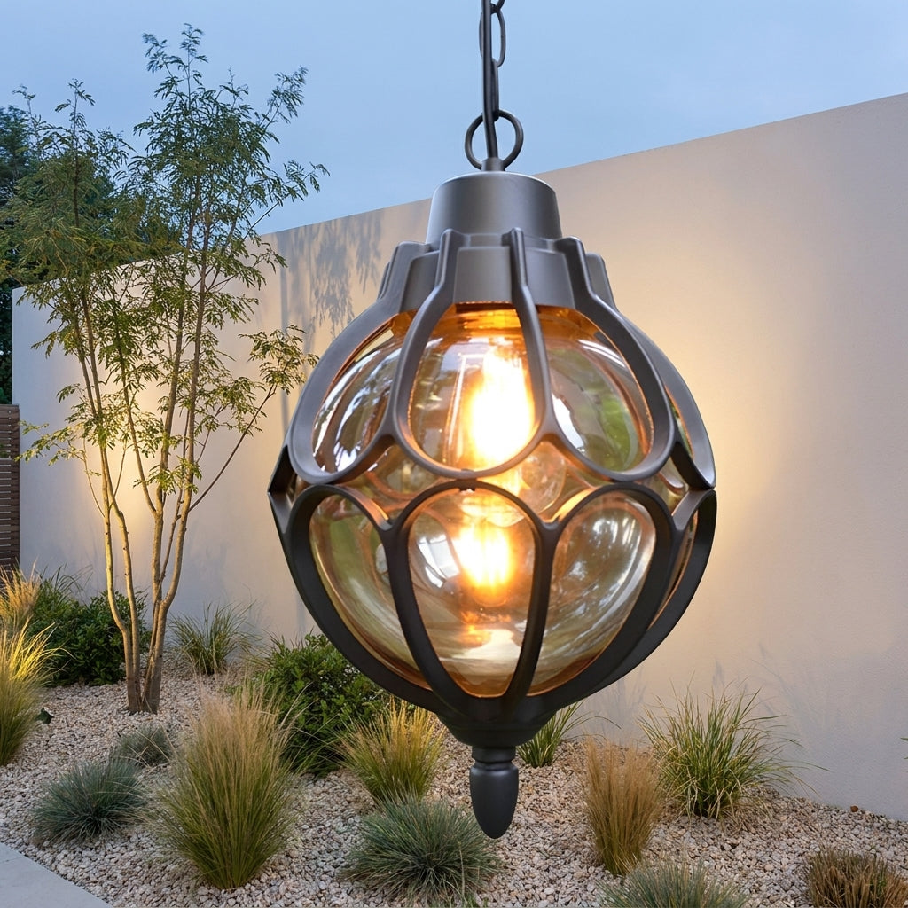 Outdoor Glass Globe Pendant Light – black finish glowing against a garden wall
