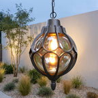 Outdoor Glass Globe Pendant Light – black finish glowing against a garden wall