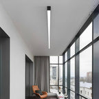 Slim Dimmable LED Linear Ceiling Light – lit above a lounge chair beside tall windows