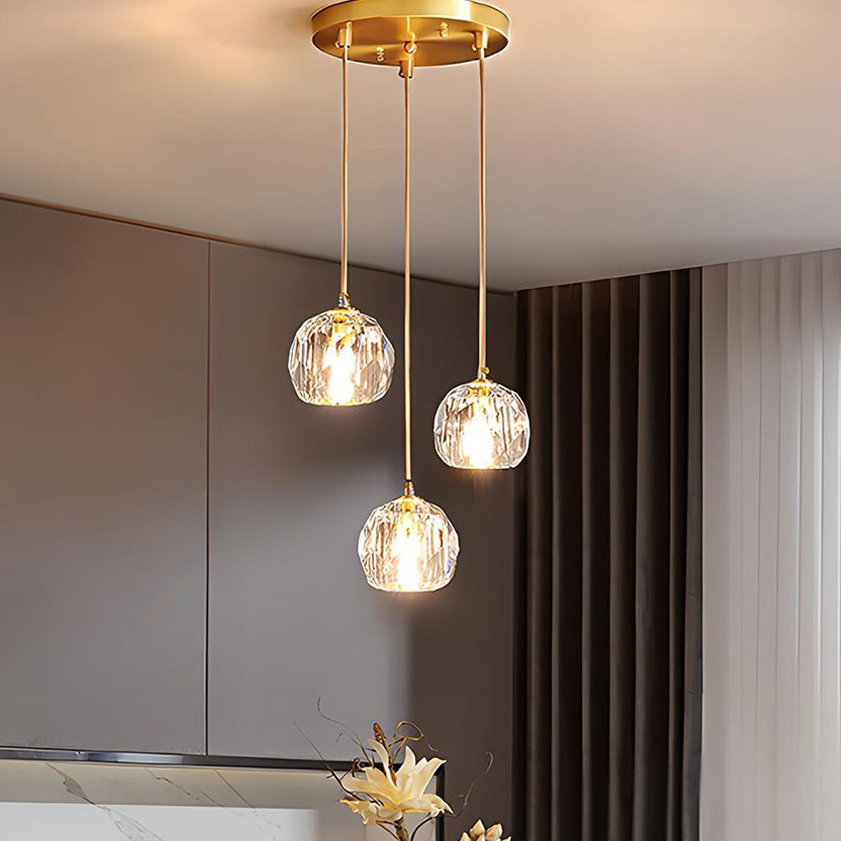 Brass & Crystal Dimmable Pendant Light – three round pendants in a dim room corner