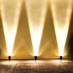 Solar Zoom Garden Spotlight – three spotlights uplighting a wall at night
