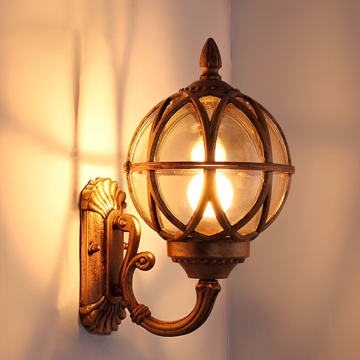 Bird's Nest Outdoor Wall Lantern – antique bronze finish lit in a corner