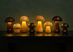 Otto Mushroom Table Lamp – group of colour finishes lit together on a dark shelf