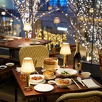 Wren Fabric Table Lamp – lit on a table in a dim restaurant