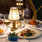 Wren Fabric Table Lamp – lit on a dining table beside plated food