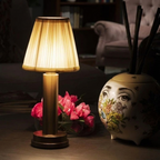 Wren Fabric Table Lamp – lit on a table beside flowers at night
