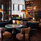 Wren Fabric Table Lamp – lit on a table in a wood-panelled bar