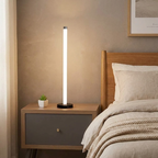 Slimline 360 LED Floor Lamp – lit on a bedside table beside the bed