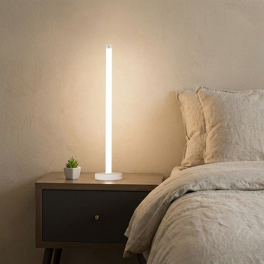 Slimline 360 LED Floor Lamp – lit on a bedside table, white finish