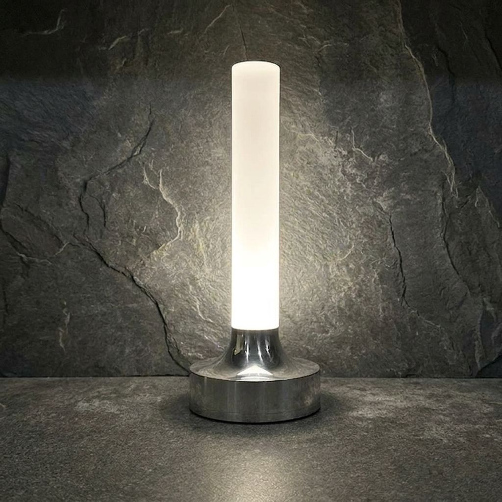 Ebba Table Lamp – lit close-up on slate tile, chrome finish