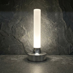 Ebba Table Lamp – lit close-up on slate tile, chrome finish