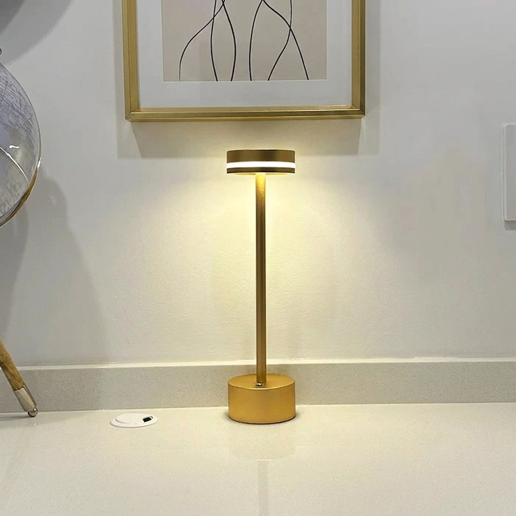 Halden Cordless Table Lamp – lit on a countertop below a framed print