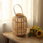 Reed Bamboo Candle Lantern – lit on a wooden stool beside sunflowers
