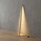 Linden Wooden LED Floor Lamp – leaning against a wall on wooden flooring