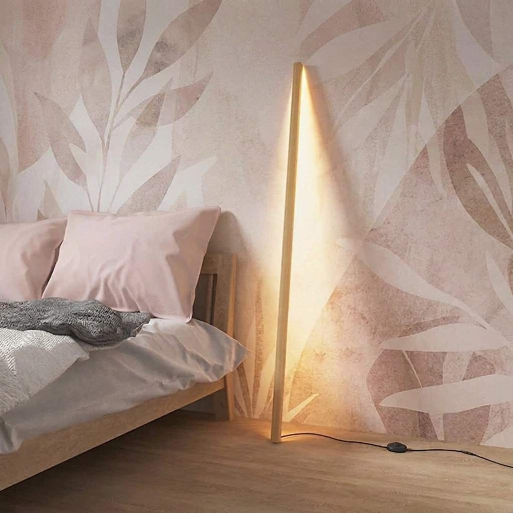 Linden Wooden LED Floor Lamp – lit leaning against a floral wallpaper wall