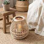Cove Rattan Candle Lantern – lantern on a wooden stool beside a bed